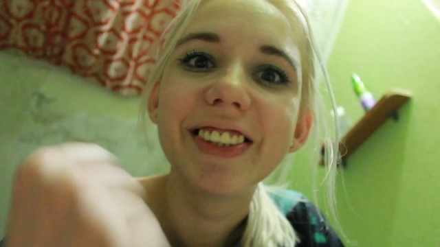 Белокурая стерва в круглых очках облизывает леденец и гладит себя