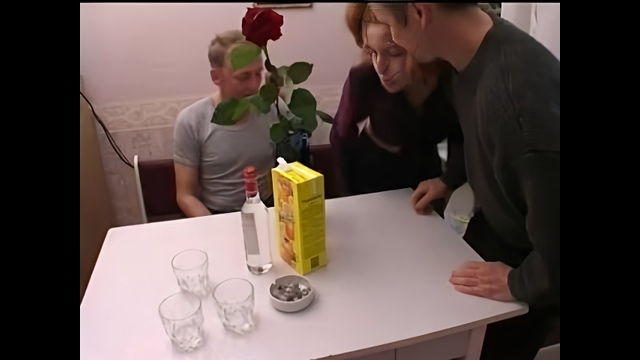 Молодая россиянка с мужчинами выпивает водку на кухне и занимается групповым сексом