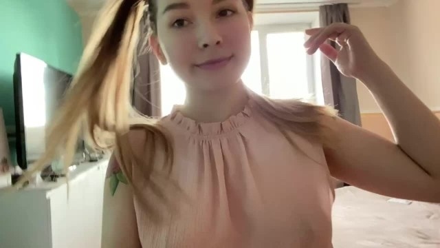 Девка с двумя хвостиками сидит на кровати и прикладывает к клитору современный вибратор